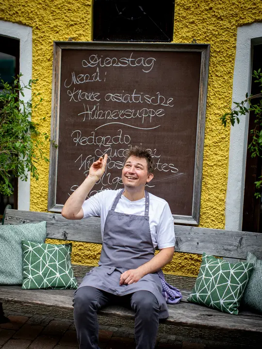 Daniel Leitner vor der Menütafel.